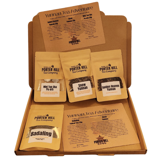 A Porter Hill Tea Company Yunnan Tea Adventure gift box set containing five different tea pouches arranged inside a brown cardboard box with printed tea guides.