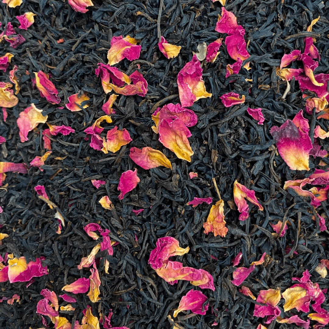 Close-up of Keemun black tea leaves scattered with dried pink rose petals
