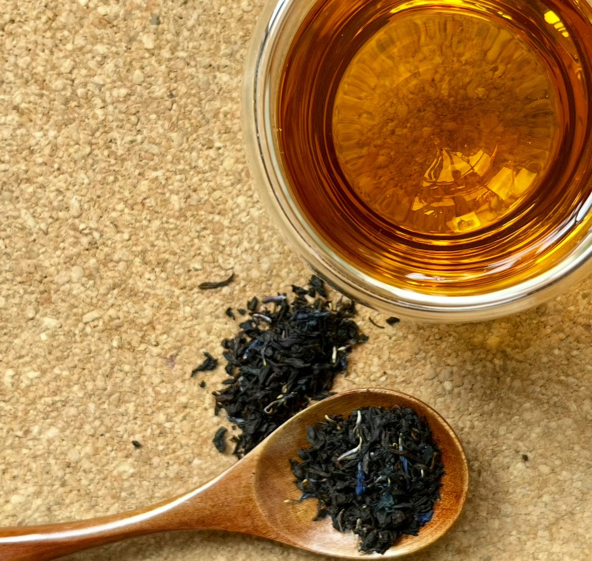 Earl Grey tea beside loose leaves in a wooden spoon