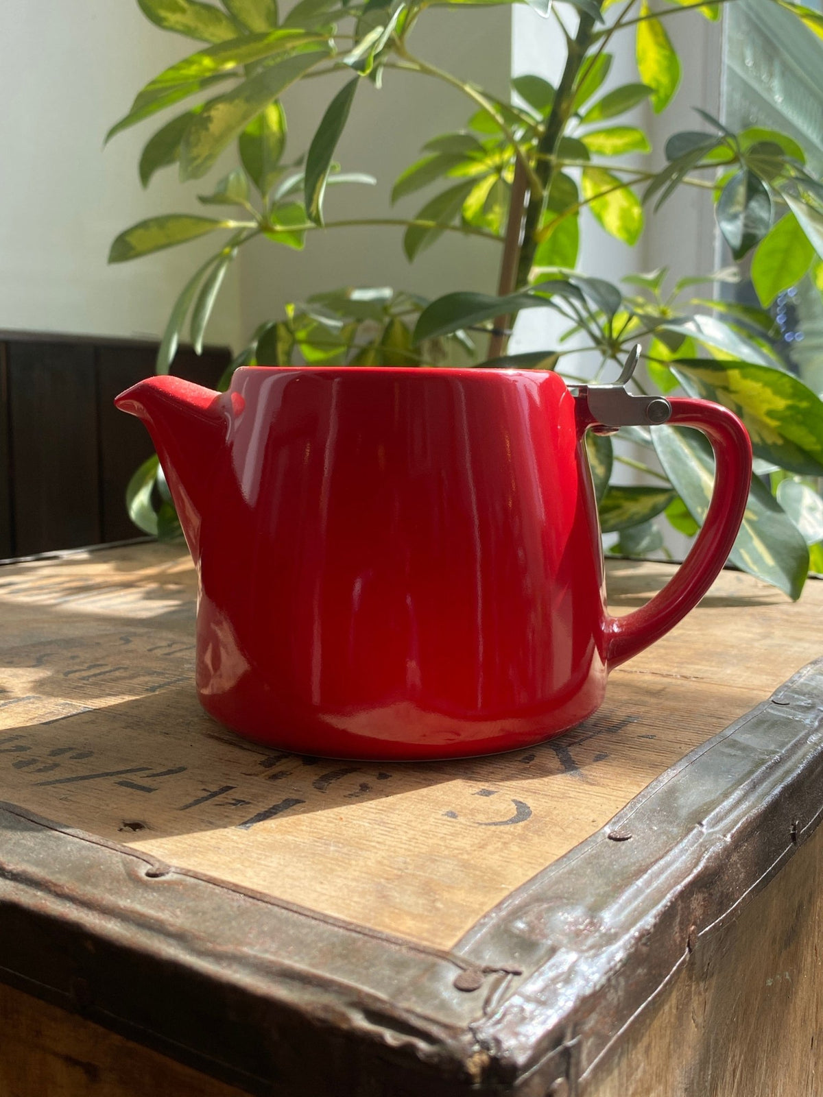Red FORLIFE Stump teapot photographed on a wooden table in the shop