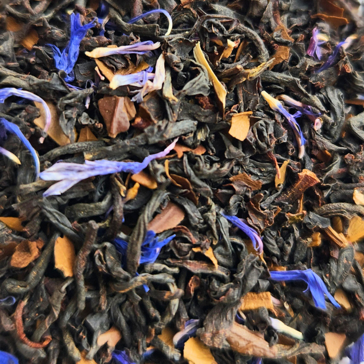 Close-up of dark Terrier Tea leaves with brown leaf pieces and blue cornflower petals