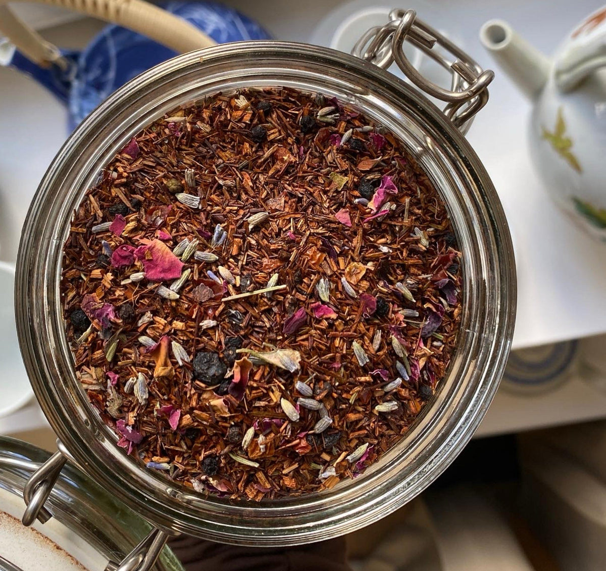Rooibos de Provence with colourful flower petals in an open tea jar