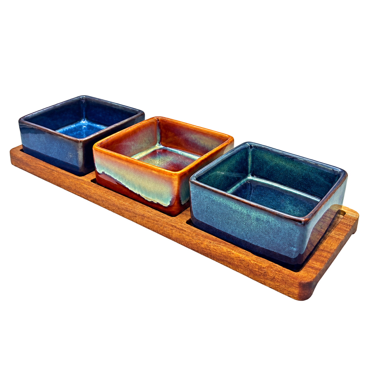 Elements set of three square glazed snack bowls in blue, amber and teal on a wooden serving tray