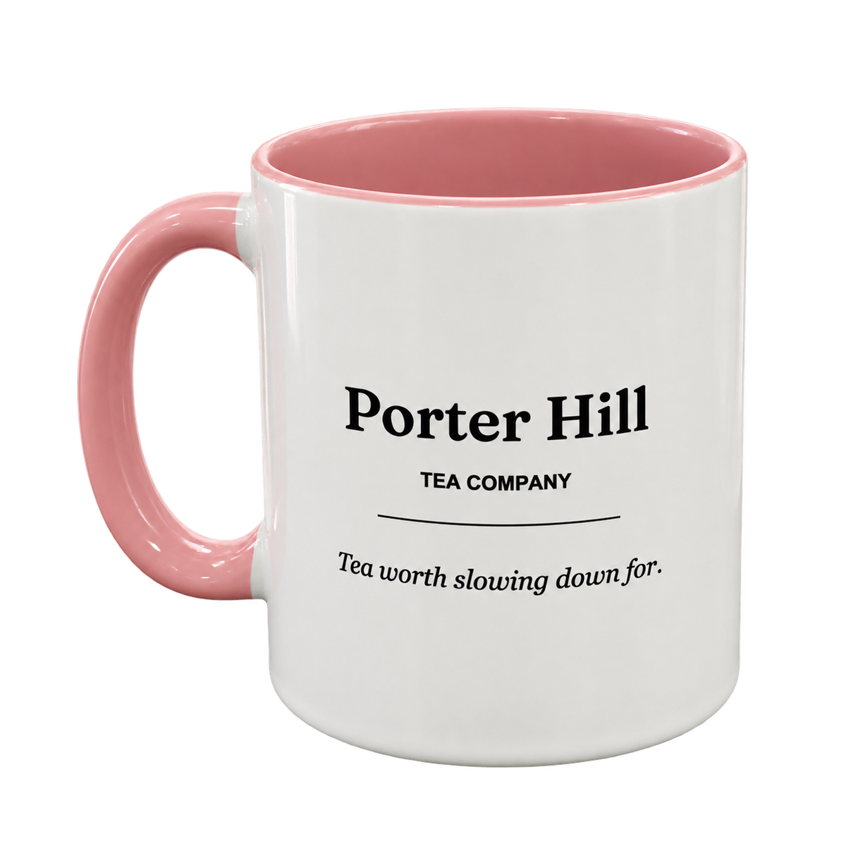 White Porter Hill tea mug with pink handle and matching pink interior, showing the logo and Tea worth slowing down for slogan